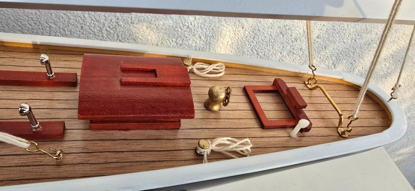 Detailaufnahmen von einem Segelschiffdeck mit Holzverkleidung und maritimen Zubehör.