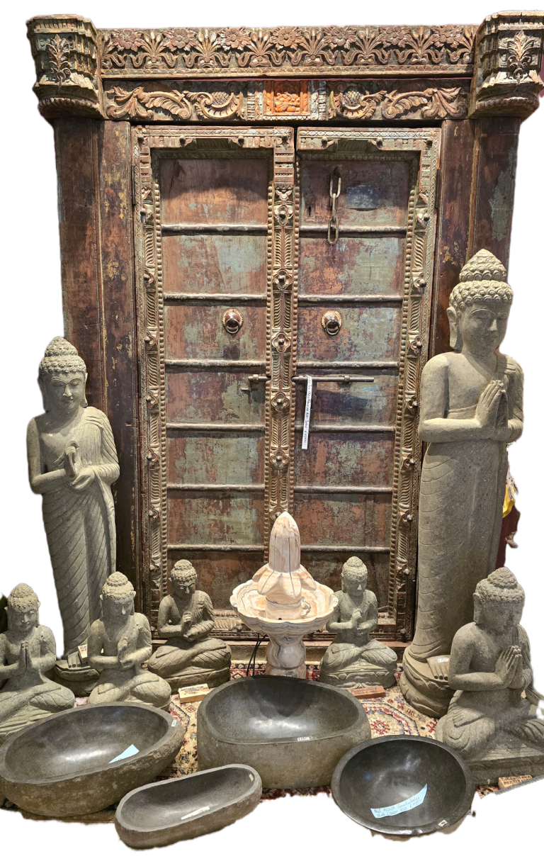 Zwei Buddha-Statuen umgeben von Figuren und Schalen vor einer geschnitzten Tür.
