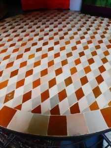 Bodenmuster mit diagonalen Rauten in Orange- und Beigetönen.