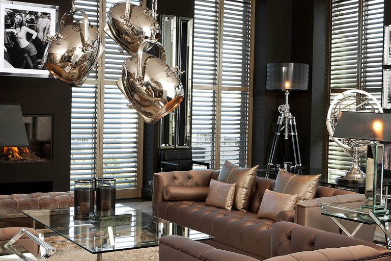 Elegantes Wohnzimmer mit beigem Sofa, modernen Leuchten und großen Fenstern.