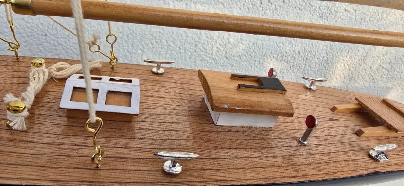 Detailansicht eines Bootdecks mit verschiedenen Elementen wie Klampen und einem Steuerpult.