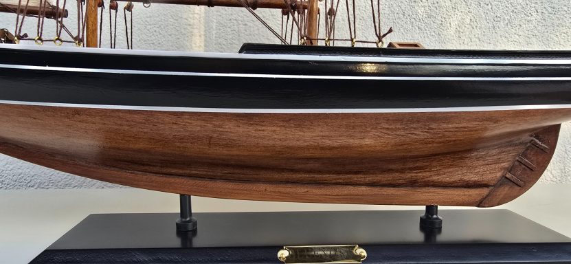 Detailaufnahme eines Holzmodellbootes auf einer schwarzen Basis.