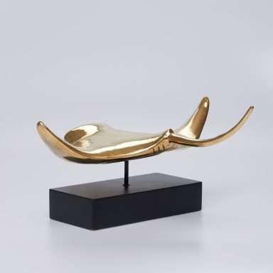 Goldene Skulptur eines Schwans auf schwarzem Sockel.