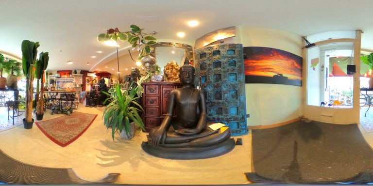 Buddha-Statue in einem kunstvoll dekorierten Raum mit Pflanzen und künstlerischen Elementen.