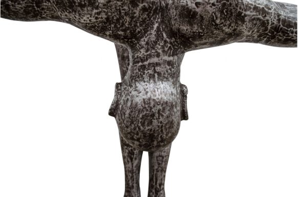 Skulptur eines menschlichen Körpers mit ausgestreckten Armen und einer runden Form.