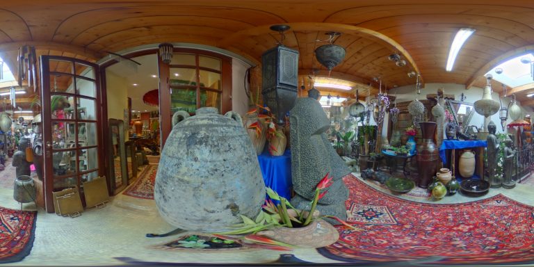 Ein runder Raum voller Kunsthandwerk, Pflanzen und bunten Dekorationen.