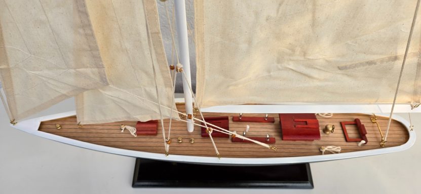 Detailreiche Schiffmodell mit weißen Segeln und einem Holzdeck.