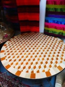 Kreisförmiger Tisch mit geometrischem Muster in Orange und Beige.