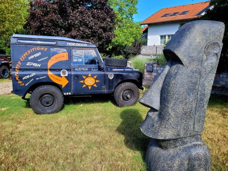 150 cm Moai vor altem Land Rover
