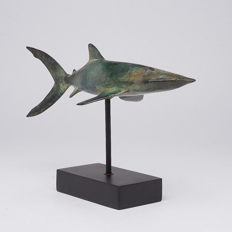 Bronzefigur eines Haifischs auf schwarzem Sockel.