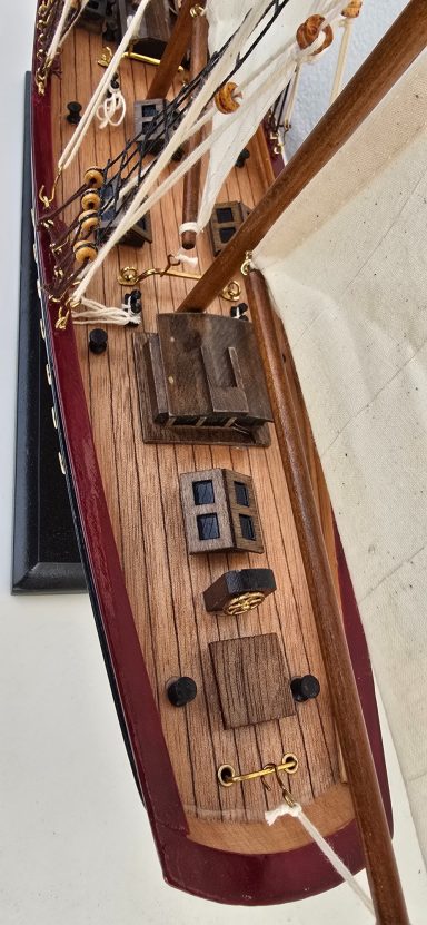 Detailansicht eines Schiffsdecks mit Holzoberflächen und sichtbaren Elementen.