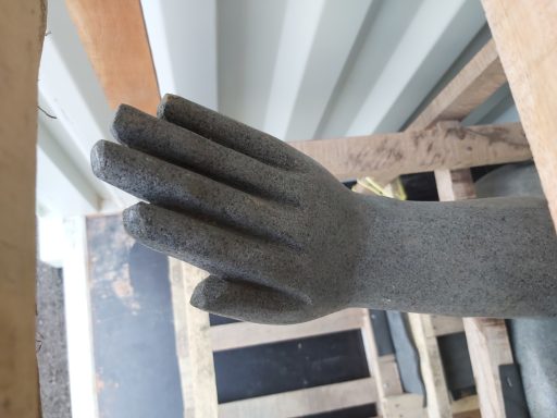 Graue, stilisierte Hand auf einer Holzpalette, leicht schräg positioniert.