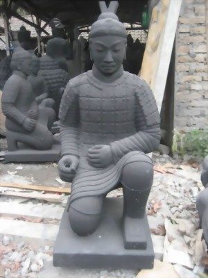 Steinerne Buddha-Statue, aufrecht stehend, Hände in der Rad der Lehrehaltung.