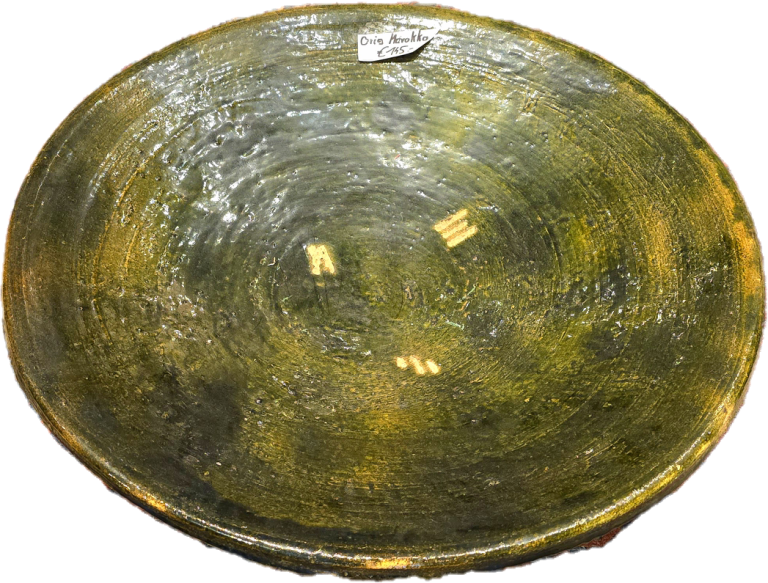 Grüne, flache Schale mit leicht eingekerbter Oberfläche und goldenen Verzierungen.