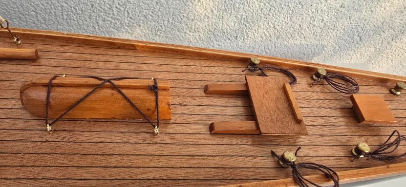 Detailansicht eines Holzbootes mit Zubehör und verschlungenen Seilen.